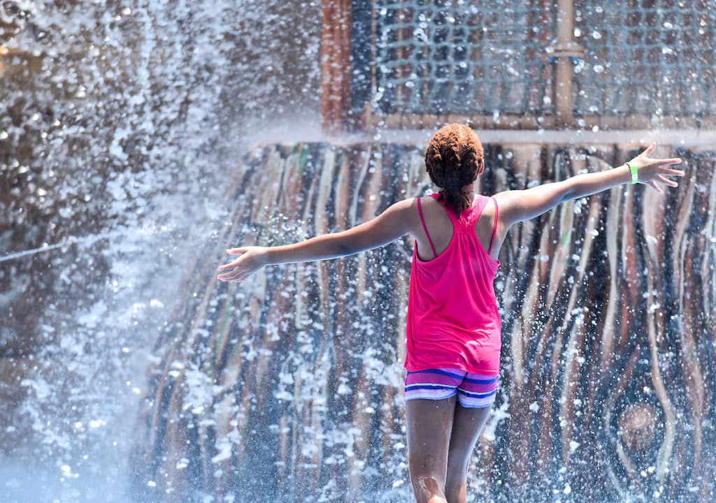 girl running and splashing on splash pad